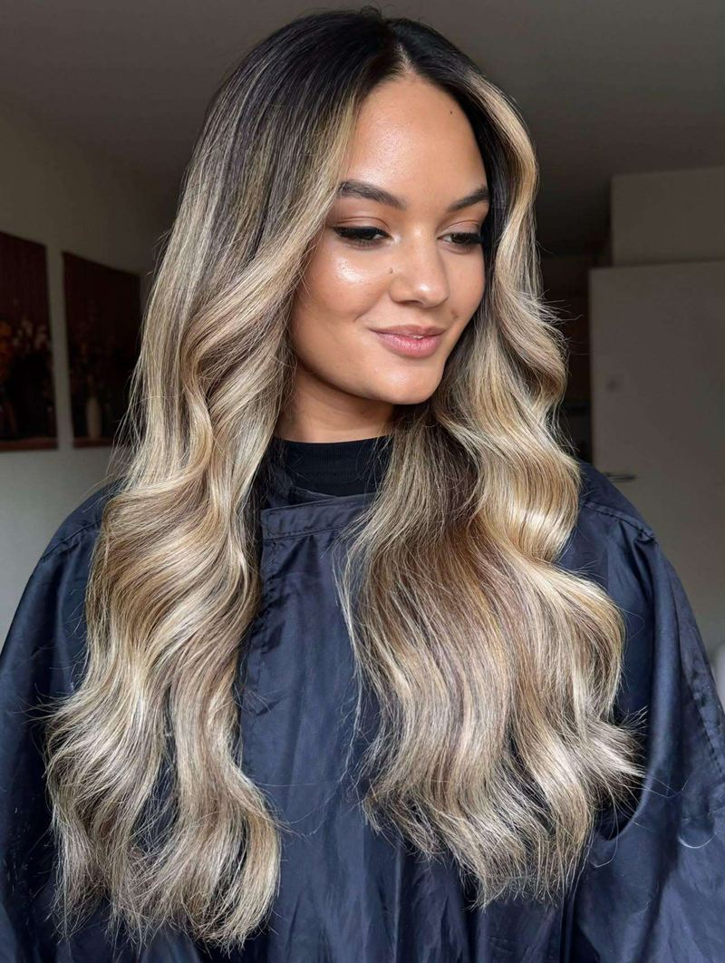 Balayage blond beige sur base foncée, longues ondulations